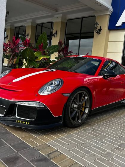 Another angle of the eye-catching red Porsche 911 GT3, this time parked near our main entrance, showcasing its powerful and aerodynamic design.