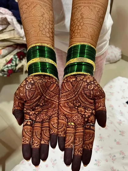 The deep, dark stain of this bridal mehendi looks incredible with the traditional green wedding bangles.