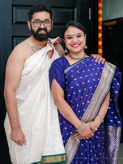 A happy couple poses at the entrance of their new home during their Gruha Pravesh ceremony. I document this significant milestone, capturing the pride and joy of starting a new chapter together.