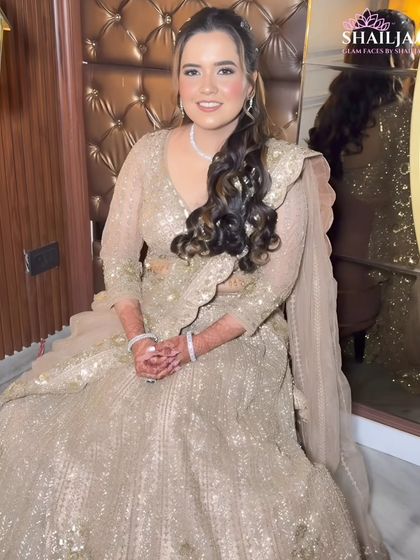 A full view of Vidushi's engagement look. She is seated gracefully in her shimmering lehenga, with her makeup and hair done to perfection.