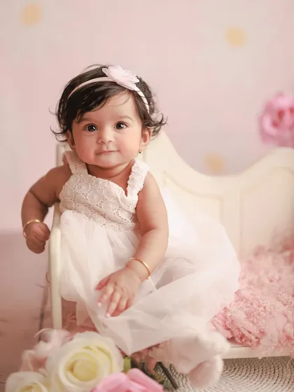 A precious portrait from a six-month milestone session. The soft pink tones and floral details create a delicate and dreamy setting for this little princess.