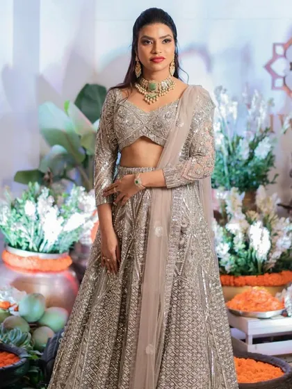 A reception look that is pure elegance. For this bride, I created a sophisticated glam style with a flawless base, defined eyes, and a classic red lip to complement her stunning silver lehenga, making her shine on her big night.