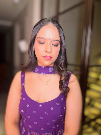 A close-up of the soft, shimmery eye makeup that complements the purple outfit.