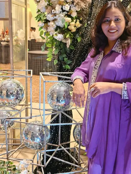 A stylish pose next to the disco ball decor at a silver jubilee party. The theme was fun and glamorous, just like the couple.