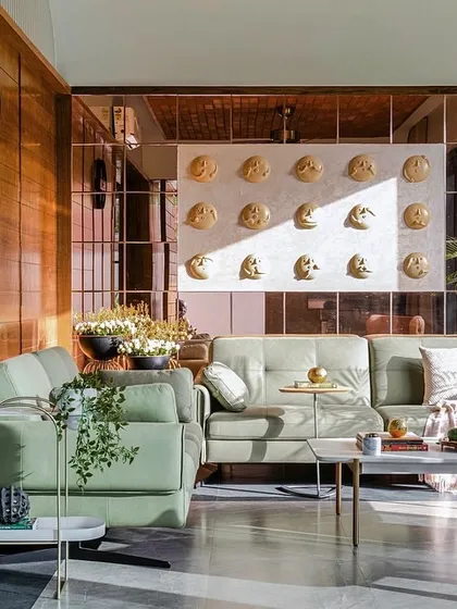 The living room of the Tranquil Mango Haven is a study in texture and light. I used warm wood paneling, soft green upholstery, and a mirrored wall to reflect the garden, ensuring the interior space feels open, calm, and constantly in conversation with the nature outside.