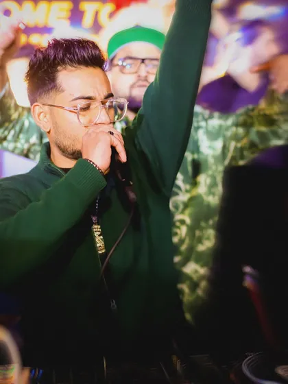On the mic with my hand up, leading the Christmas Eve party. I am an active performer, not just a DJ who stands behind the console.