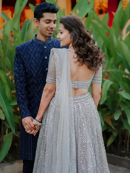 A candid moment between the couple at their reception. The bride's hair is styled in soft waves, and her makeup is a perfect example of "fierce glam".
