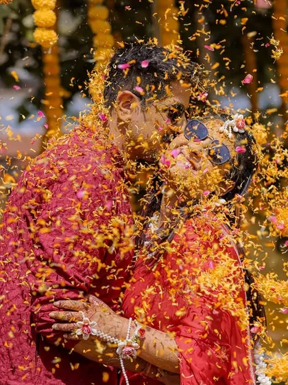 Haldi is all about pure, unadulterated joy. I love getting right into the middle of the celebration to capture moments like this one, a spontaneous kiss amidst a shower of marigold petals. These are the candid, colorful memories that you'll cherish forever.