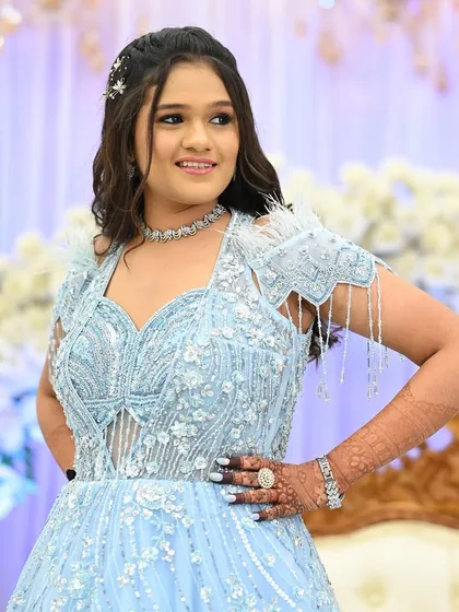 This young guest is looking like a princess in her blue gown, with her henna adding to the festive charm.