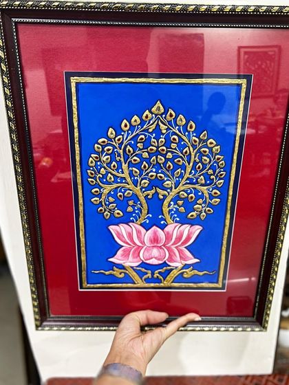 A completed and framed Tanjore painting of the Bodhi tree and lotus, showcasing the rich colors and gold details typical of this art style.