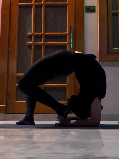 Practicing a forearm wheel pose (Viparita Dandasana) indoors. This deep backbend is a variation of the traditional wheel pose that challenges shoulder and thoracic spine mobility.