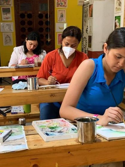 Students practice watercolor techniques in a bright and airy classroom. The environment is designed to be both inspiring and conducive to focused, productive work.