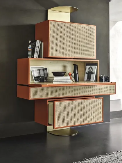 This retro-inspired cabinet draws inspiration from the Memphis movement. It features a playful, asymmetrical stacking of boxes finished in a bold color, with woven cane door fronts and brushed brass accents.