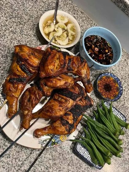 Perfect for outdoor events and barbecues, our grilled chicken legs are marinated in a blend of spices and cooked until tender and juicy. They are served here with fresh okra and dipping sauces for a complete meal.