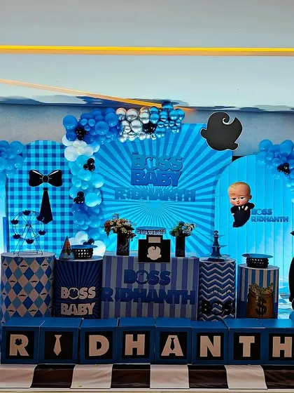 We love bringing fun themes to life, like this "Boss Baby" setup for Ridhanth's celebration. The decor includes custom character cutouts, themed props like money bags, and a coordinated blue, black, and white balloon and backdrop design.