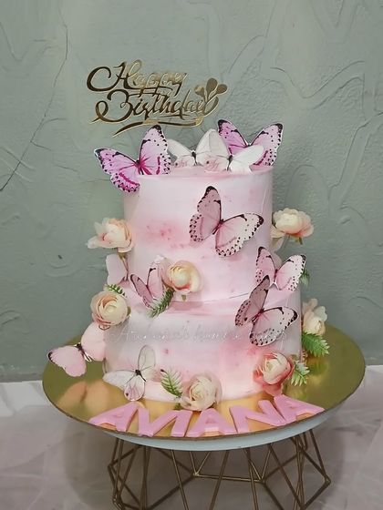 A two-tiered pink ombre cake covered in beautiful butterflies. This is one of my favorite designs to create.