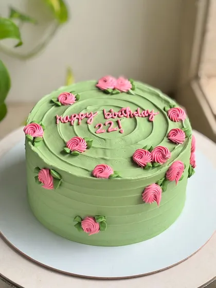 22 and blooming. This cake pairs a soft sage green buttercream with delicate pink rosettes for a timeless and fresh birthday design.