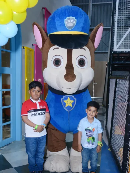 Ready for a ruff-ruff rescue! Two young guests pose with a Chase mascot at a Paw Patrol themed birthday party.