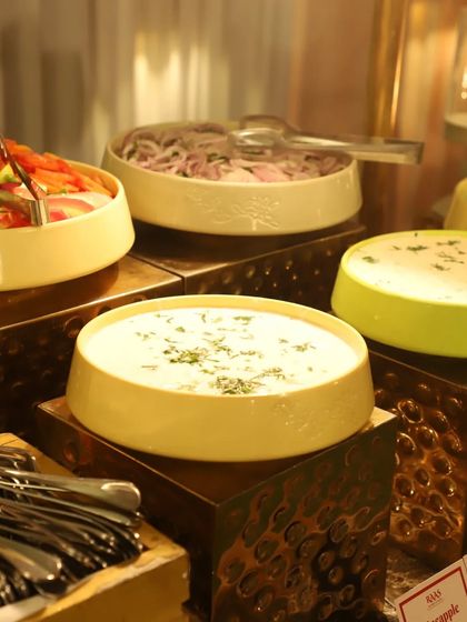 A fresh and crisp salad bar is an essential part of my buffet. I provide a variety of options, including sliced onions, mixed green salad, and different types of raita like Burani and Pineapple raita.