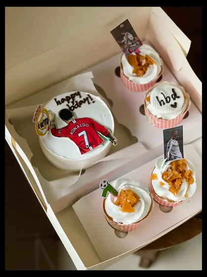 Perfect for a football fan, this Cristiano Ronaldo themed set includes a bento cake with his iconic celebration pose and cupcakes with edible toppers. The butterscotch crunch on the cupcakes adds a delicious texture.