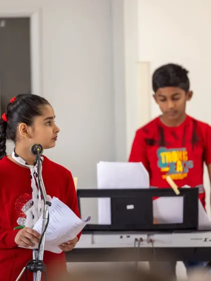 A young vocalist and keyboardist performing together. Our initiative encourages collaboration between students of different ages and instruments.