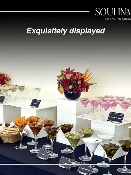 An exquisitely displayed appetizer bar featuring a variety of dips and snacks in elegant martini glasses. A perfect setup for a cocktail reception.