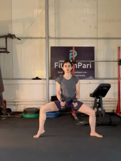 A plié squat hold with dumbbells. Isometric holds are a great way to build muscular endurance and mental toughness.