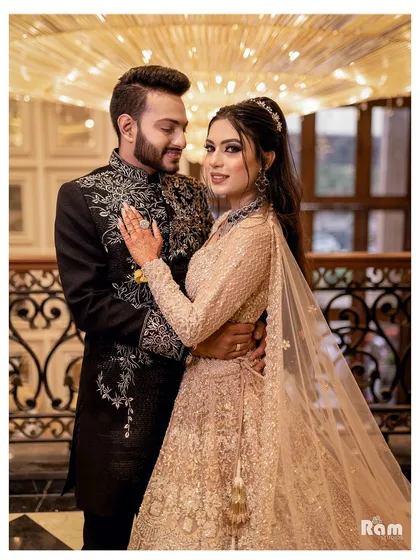A classic and elegant portrait of the newly engaged couple. Their beautiful traditional attire and confident poses make for a stunning photograph under the warm chandelier light.