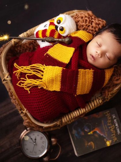 A magical, sparkling effect adds to the enchantment of this Harry Potter newborn photo, with the wand appearing to cast a spell.