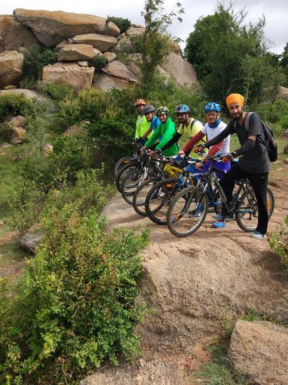 The crew navigating a rocky, scenic trail surrounded by lush greenery.