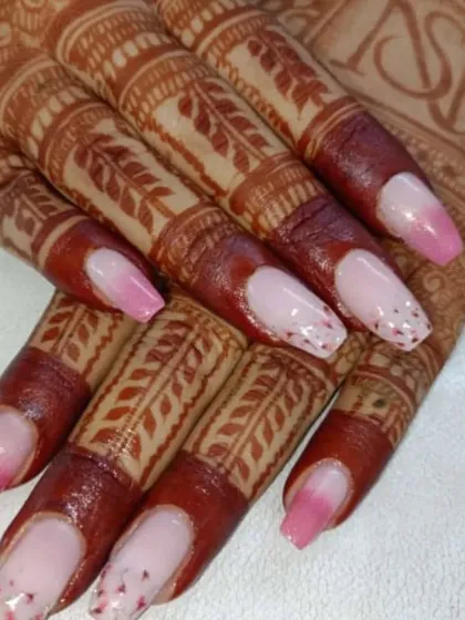 A delicate and pretty bridal design featuring a pink ombre base with subtle glitter and dot accents. This is a lovely choice for a more understated yet beautiful wedding manicure.