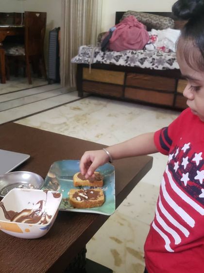 Another angle of our chocolate day activity, showing the student's concentration as she prepares her snack.