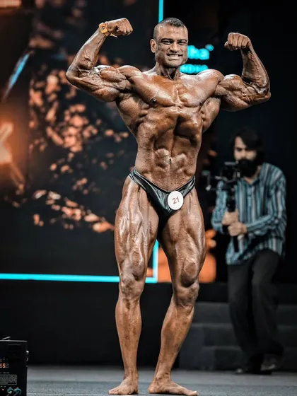 The Front Double Biceps is a game-changer. It displays the complete muscularity, conditioning, and symmetry of your physique. This is me on stage, hitting the pose with the confidence and technical precision that I teach all my clients.
