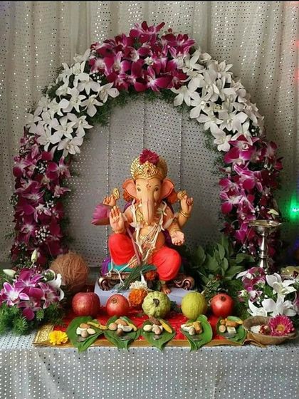 A beautiful arch of white and purple orchids for a Ganpati mandap. The simplicity of the flowers against the sequined backdrop creates a look of pure elegance.