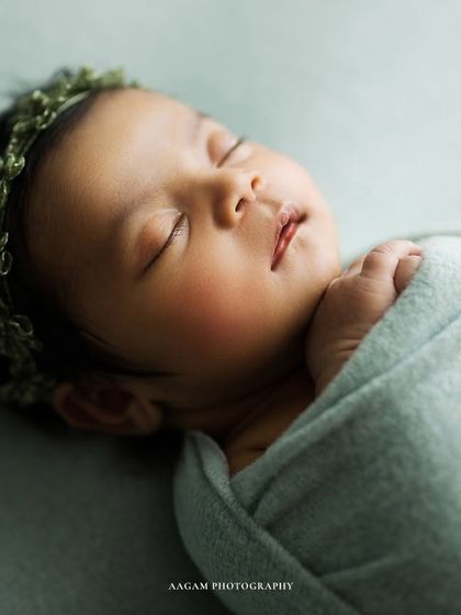 A slightly different angle, showing the baby's sweet profile and the delicate green floral headband.