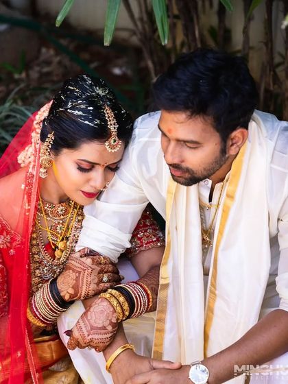 A tender moment between the couple, with a focus on their intertwined, henna-stained hands. The rich color adds warmth and intimacy to the photograph.