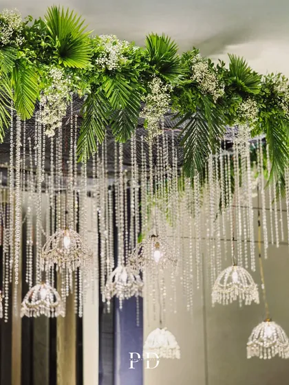 The top of the crystal entrance, showing the lush arrangement of palm leaves and baby's breath from which the crystal strings and chandeliers are suspended.
