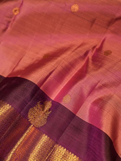 The soft drape of this pink Kanjivaram, showing the subtle sheen of the silk and the intricate paisley motifs woven into the border.