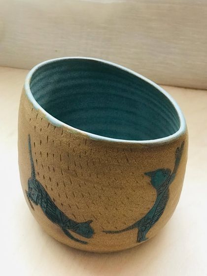 For the cat lovers, my "Midnight Mischief" bowl. This hand-thrown piece features etched feline silhouettes dancing around the outside, with a deep teal blue glaze on the inside.
