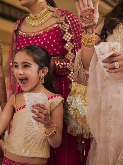 The pure excitement of a young flower girl enjoying the wedding festivities, a precious candid moment.