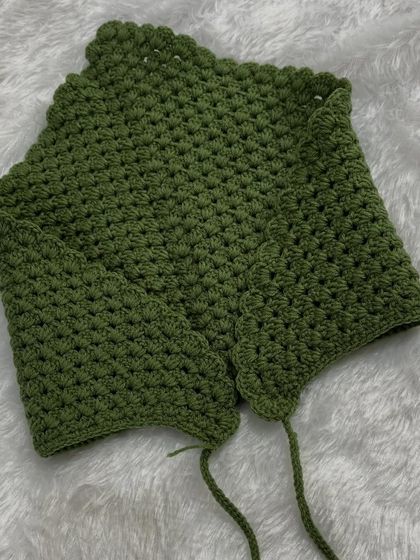 My crochet bandana laid flat, showing its triangular shape and the simple ties. This classic design is easy to wear and style.