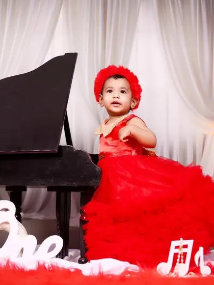 A full view of the elegant red and white piano theme for a first birthday celebration.