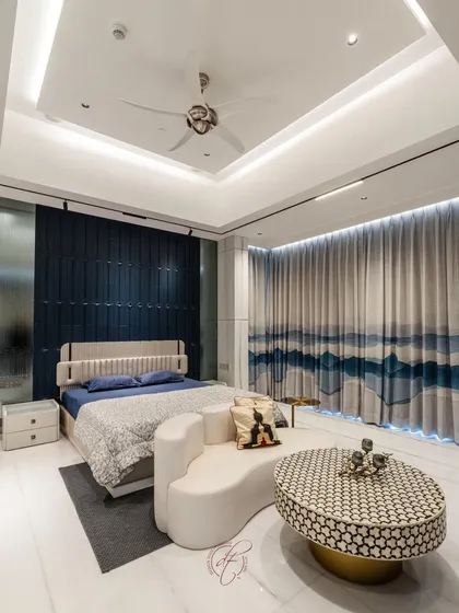 The view from the side highlights the beautiful, ocean-inspired curtains that complement the blue accent wall. The room is a perfect balance of bold design choices and serene, calming elements.