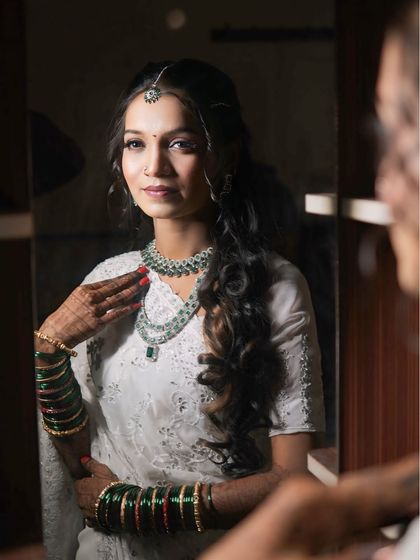 Another mirror shot, this time with the bride looking directly at her reflection. The hairstyle is designed to be both beautiful and photogenic.