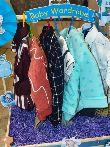 The baby boy's wardrobe cart from the twins' gift set, with a collection of shirts and pants.