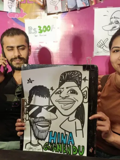 A couple with their caricature at our stall. You can see my price list and other examples hanging in the background.