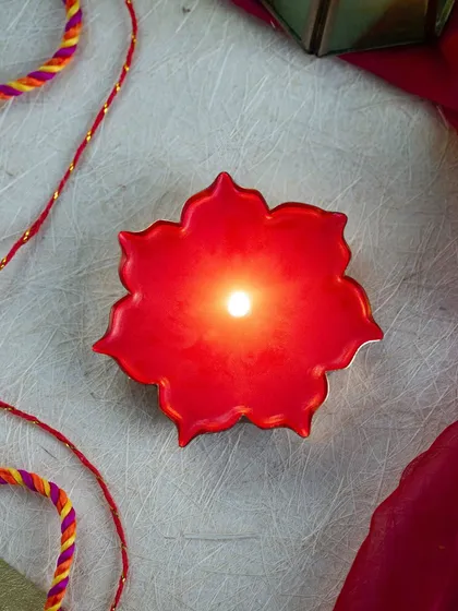 An overhead view of the red floral candle, showing how the light pools in the center. It's a simple piece that makes a big impact.