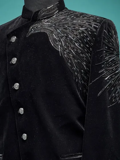 A close-up of the handwork on a black velvet Jodhpuri. The silver embroidery depicts a powerful bird wing, adding an artistic and symbolic touch.