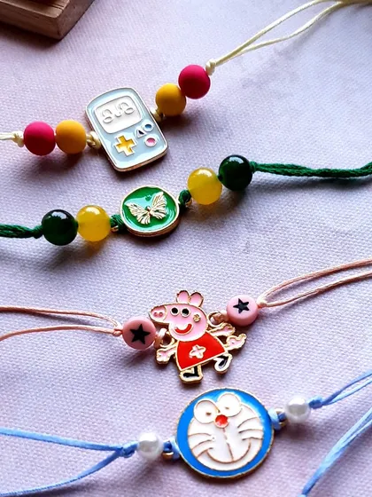 A spotlight on some of my most-loved character Rakhis for kids. You can see Peppa Pig and Doraemon alongside a cute gaming console charm, all on simple, colorful threads.
