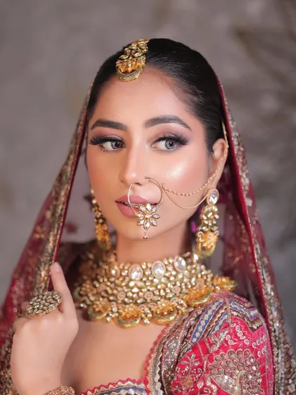 A side profile of this stunning bride, highlighting the flawless base, intricate jewelry, and the overall elegance of her traditional look.